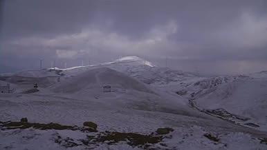 山顶下雪雪景阳光白色群山风力发电奇观视频的预览图